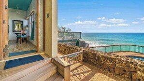 A private beach with a stone wall and a wooden deck.