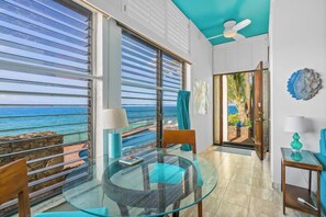 Enjoy ocean views from the comfort of your room, with a clear view through large windows and a door leading to an outdoor area.