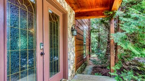 A stone exterior with a wooden porch and a door with glass panels. - Big Bear Lodge: Mountain Views, Game Room (Sevierville)