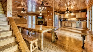 A wooden interior with a dining area, kitchen, and staircase. - Big Bear Lodge: Mountain Views, Game Room (Sevierville)