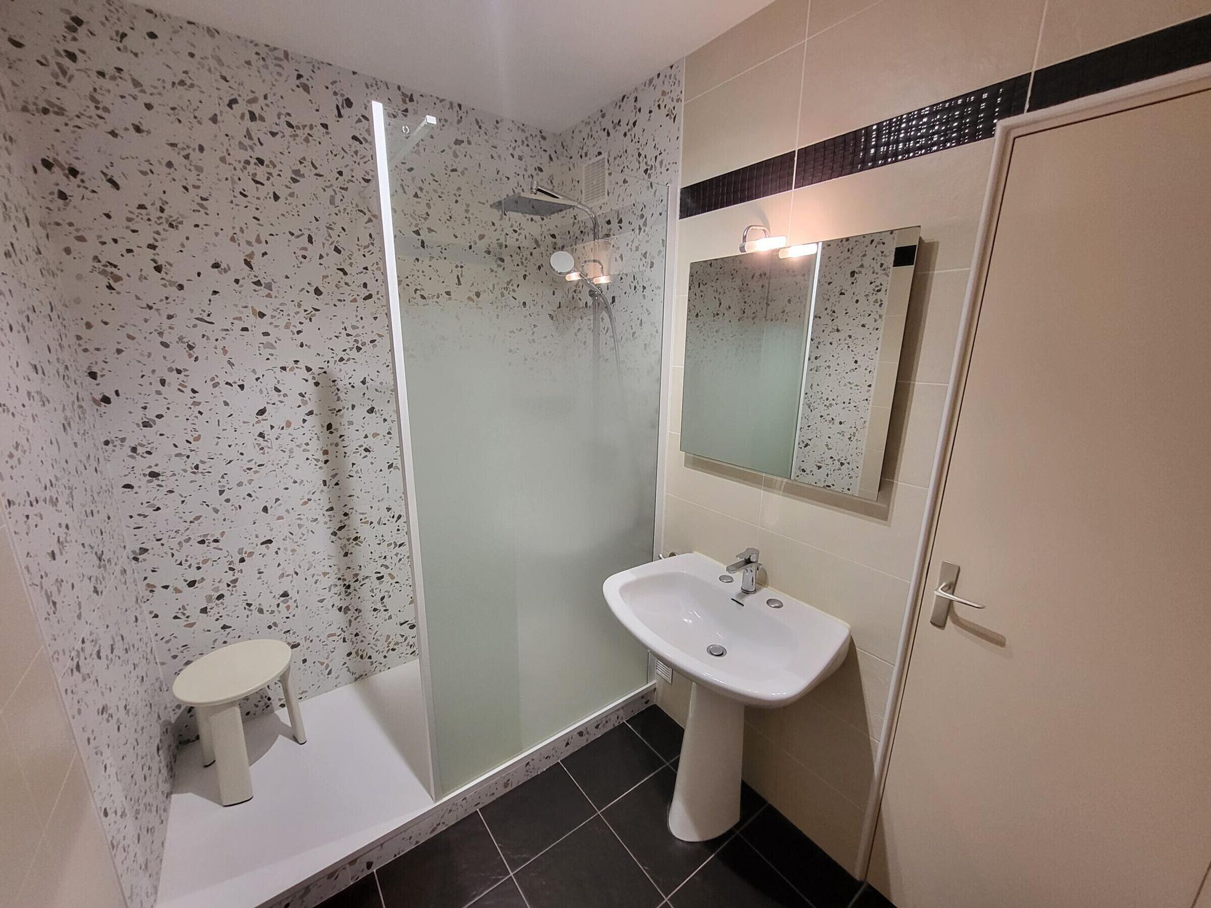A bathroom with a shower, a sink, and a toilet.