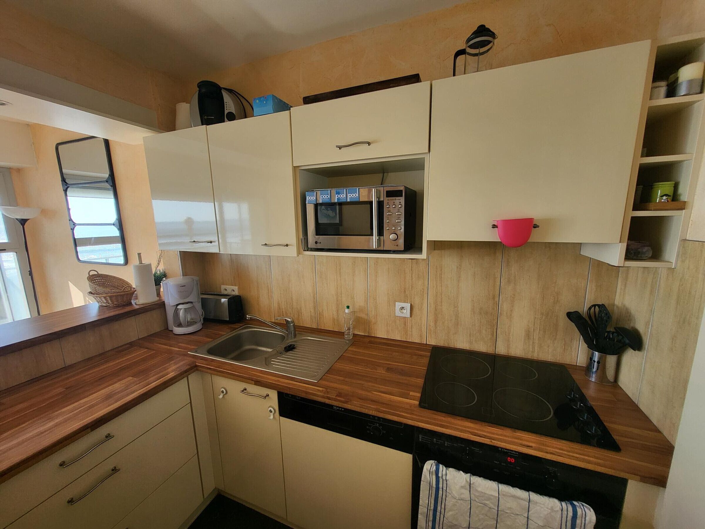 Una cocina compacta con un lavabo, un microondas y una estufa.
