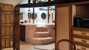 A bathroom with a mosaic sink, wooden cabinets, and a mirror.