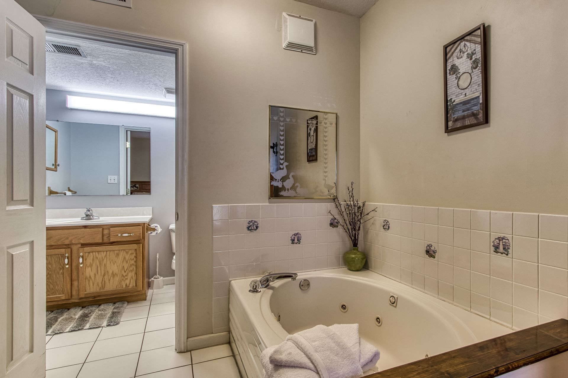 A bathroom with a bathtub, a sink, a mirror, and a toilet.
