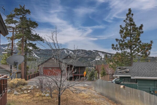 Un quartier résidentiel avec des maisons, une antenne parabolique et une chaîne de montagnes en arrière-plan.