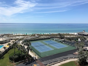 A tennis court with a view of the ocean.
