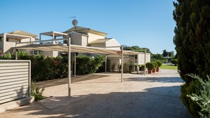 A modern house with a covered patio, potted plants, and a clear blue sky. - Helios - A paradise in nature. Luxury 2 Bedrooms (Sleeps 4-5) With Pool In Corfu (Agios Mattheos)