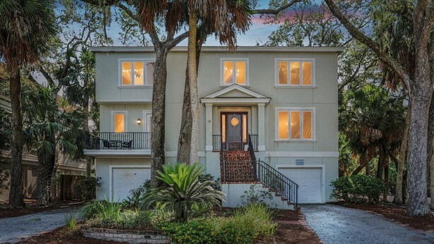 A two-story house with a front porch, a garage, and a driveway.