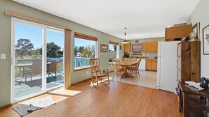 A spacious kitchen with wooden cabinets, a dining area with a table and chairs, and a sliding glass door leading to a deck.