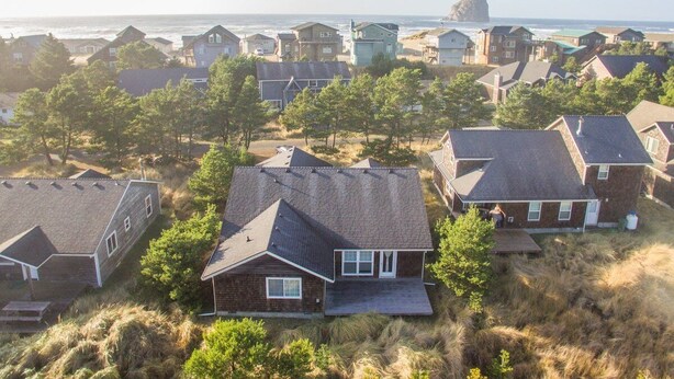 A coastal residential area with houses featuring sloped roofs and a mix of brick and siding exteriors.