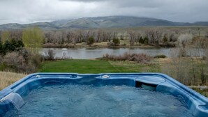 A hot tub with a view of a lake and mountains.