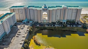 Un gran hotel con varios pisos, un patio central y vistas a la playa.