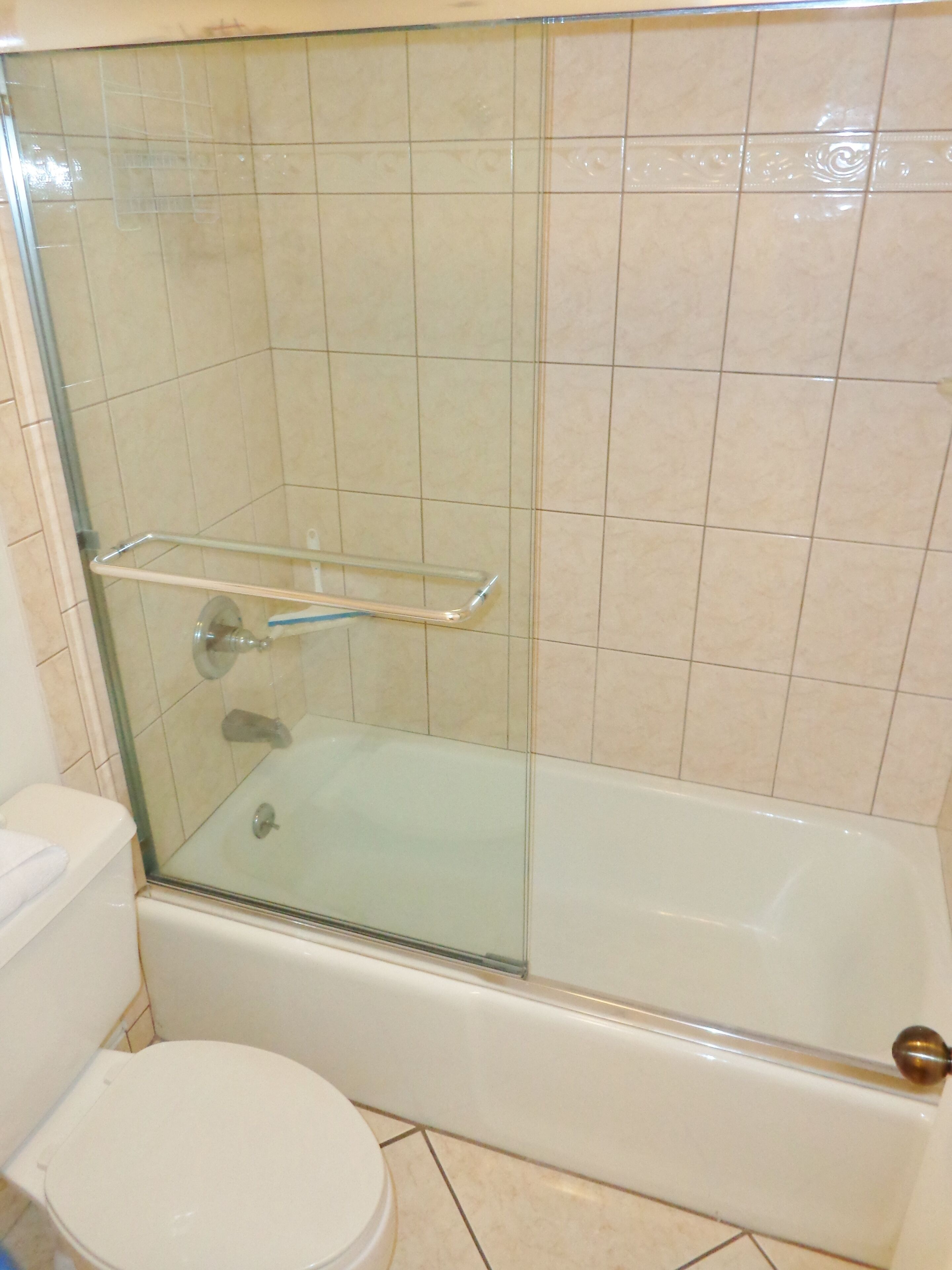 Une salle de bain avec une douche à parois de verre, une baignoire blanche et des toilettes.