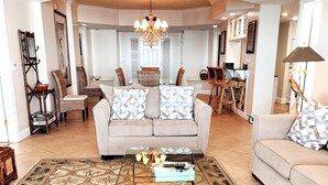 Un salón amplio con un sofá color beige, un tapete estampado y una mesa de centro.
