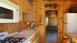 A wooden cabin-style kitchen with a stove, sink, microwave, and refrigerator. - Lake Views! Lakefront! BBQ! Internet! Close to the Village! (Big Bear Lake)