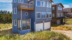 A two-story house with a balcony, large windows, and a garage. - Seaside Splendor - large home, fantastic views very, close to beach (Pacific City)