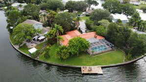 An aerial view of a residential property with a swimming pool, a dock, and lush greenery. - Key West Style Waterfront, Private Pool, WiFi, Close to Village & Beaches Pet OK (Safety Harbor)