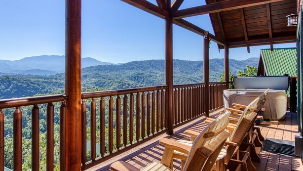 Une terrasse en bois offrant une vue sur un paysage montagneux.