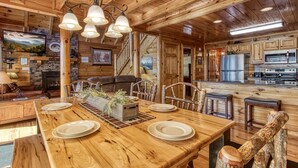 L’intérieur d’une cabane en bois comprend un coin repas, une cuisine et un espace de vie.