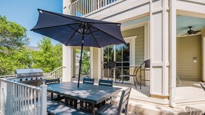 An outdoor patio with a table and chairs, a grill, and a covered umbrella. - 43 Dune Lane - 2nd Row Dune Lane Luxury, 100ft from the Sand (Hilton Head Island)