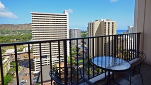 A balcony with a view of tall buildings and a road below. - Waikiki Banyan 1909 Amazing Views and Just  Steps to the Beach (Honolulu)