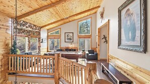 Ein Holzblockbau-Innenraum mit Steinwand, Holzboden und einem großen Fenster.