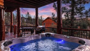 A hot tub on a wooden deck with a view of a house and trees.
