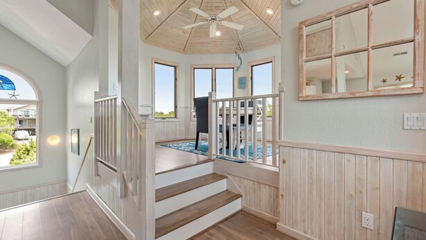 A staircase with wooden steps and a railing, leading to a balcony with a view of the outside. - Pelican Shores: Private pool, 4 bedrooms, Whalehead Beach (Corolla)
