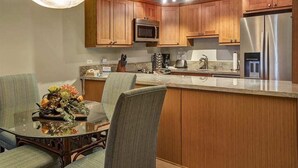 Una cucina moderna con mobili in legno, elettrodomestici in acciaio inossidabile e un'isola centrale con posti a sedere.