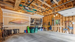 Un garage spacieux doté d’un sol en béton, de poutres en bois et d’un support à vélos fixé au mur.