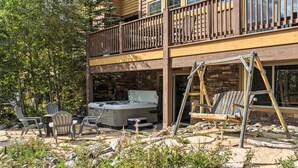 Un bâtiment à deux étages doté d’un balcon, d’un espace extérieur aménagé pour s’asseoir et d’un jacuzzi.
