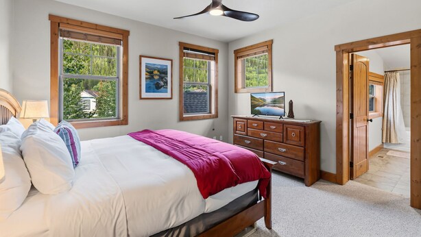 Une chambre à coucher avec un lit, une commode et un ventilateur de plafond.
