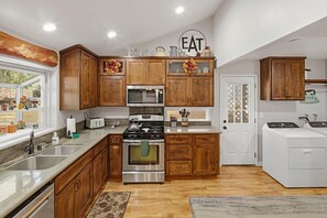 A modern kitchen with wooden cabinets, stainless steel appliances, and a built-in oven.