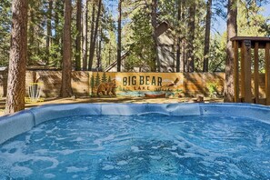 A swimming pool with a wooden fence and a mural of a bear and lake. - Outdoor Living by Snow Summit! Big Bear Mural! PET FRIENDLY! HOT TUB! Fire Pit! Large Fenced Yard! (Big Bear Lake)