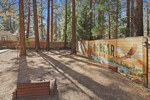 A wooden bench, a picnic table, and a mural on a wall depicting a bear and a river.