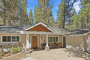 A two-story house with a front porch, a chimney, and a well-maintained garden. - Outdoor Living by Snow Summit! Big Bear Mural! PET FRIENDLY! HOT TUB! Fire Pit! Large Fenced Yard! (Big Bear Lake)