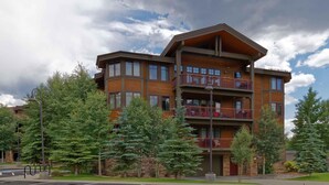 A multi-story building with a wooden facade, balconies, and a parking lot. - Beautiful 1 bedroom, 1 bath condo on Lake Dillon in Frisco. Walk to shuttle. (Frisco)