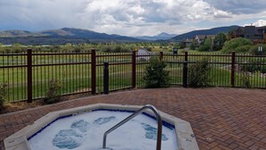 A hot tub with a metal ladder, surrounded by a brick patio and a metal fence. - Beautiful 1 bedroom, 1 bath condo on Lake Dillon in Frisco. Walk to shuttle. (Frisco)