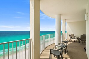 A balcony with a view of the ocean, a table with chairs, and a white railing. - CONDO WITH AMAZING VIEWS & SPACIOUS BALCONY!! SLEEPS UP TO 8! (Panama City Beach)