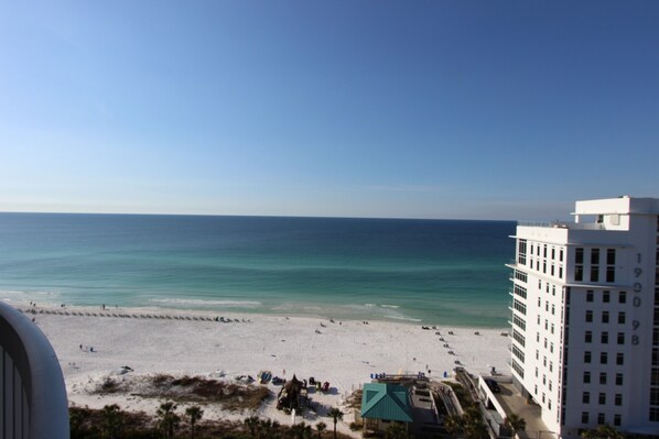 A beach view with a white building and a clear sky.