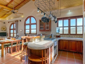 Enjoy cooking in this well-equipped kitchen with a central island and large windows offering views of the surrounding landscape.