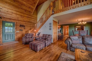 Un interior de madera con una escalera, mobiliario escocés y un sofá de cuero.