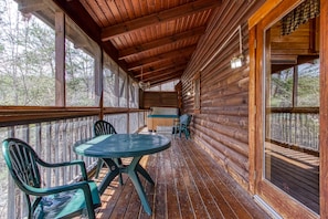Enjoy dining or socializing on the covered porch with a round table and four chairs.