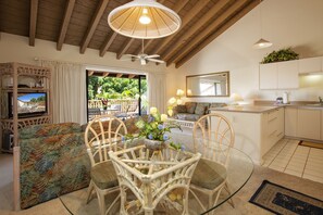 Relax in this stylish living space with a high ceiling, comfortable sofa, and dining area.