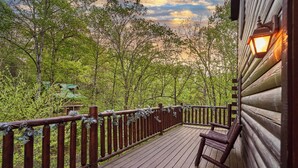 A wooden deck with a railing, a bench, and a lantern. - Private Indoor Pool Cabin • 2 King Suites (Sevierville)