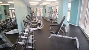 A gym with treadmills, elliptical machines, and free weights.