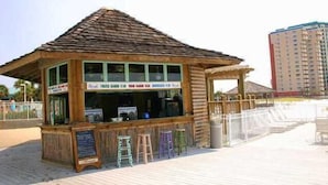 Een houten kiosk met een schuin dak, een balie en krukken.