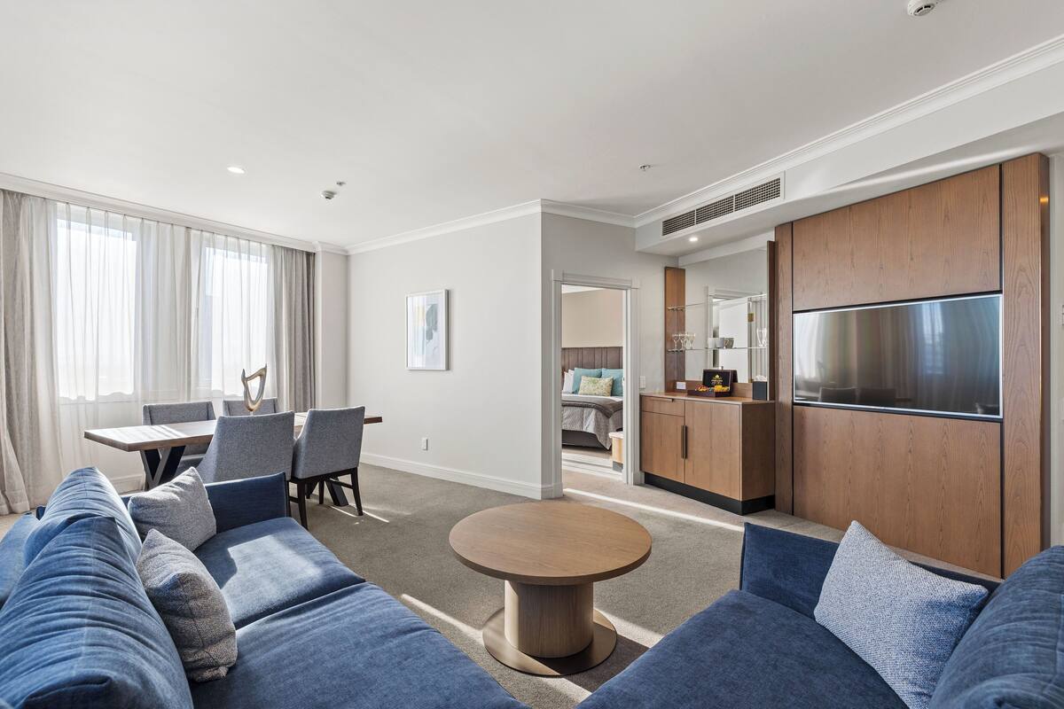 Een moderne hotelkamer met een zithoek, eettafel en kitchenette.