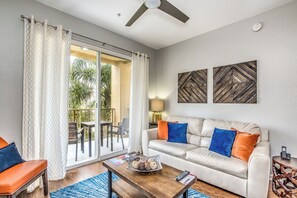 A living room with a sofa, coffee table, and a view of a balcony.