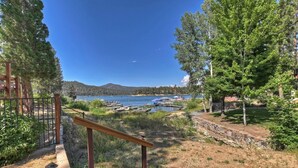 A view of a lake with boats, surrounded by trees and a stone wall.